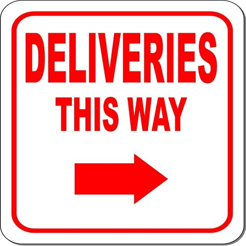 Prominent "Delivery this way" sign with an arrow at a Lagos distribution center.