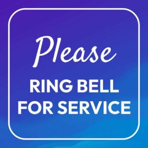 "Please Ring Bell for Service" sign on a clean counter in a Lagos shop.
